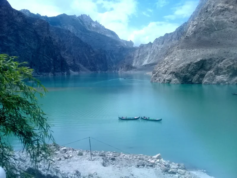 Turquoise water of Attabad Lake between steep Karakoram cliffs