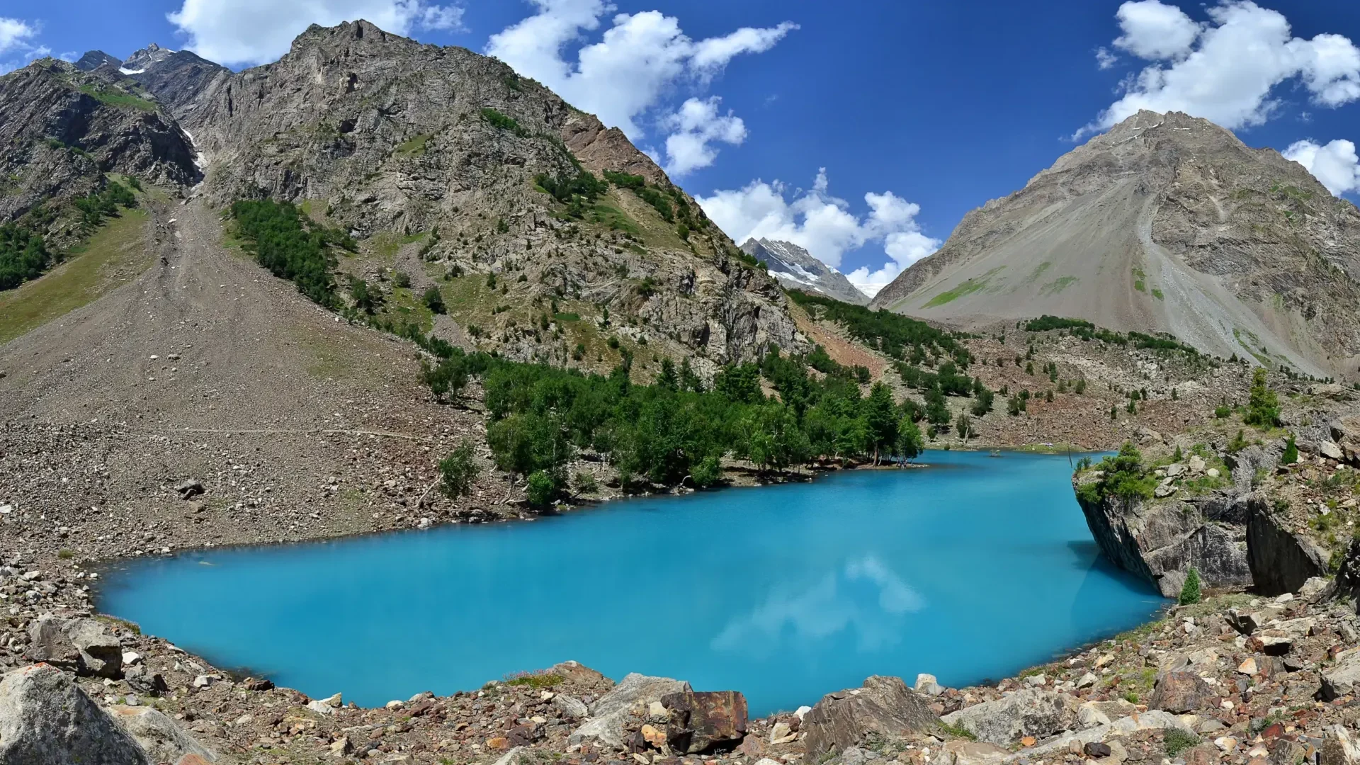 A turquoise lake among rocky slopes in Naltar Valley near Gilgit