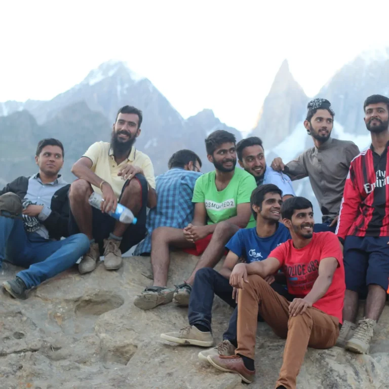 Travellers relaxing on rocks below rugged peaks