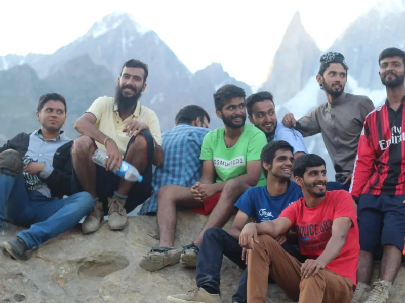 Travellers relaxing on rocks below rugged peaks