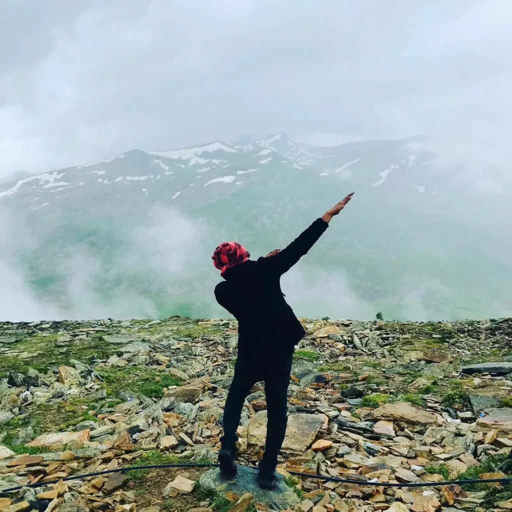 A traveller standing above the clouds on a mountain ridge